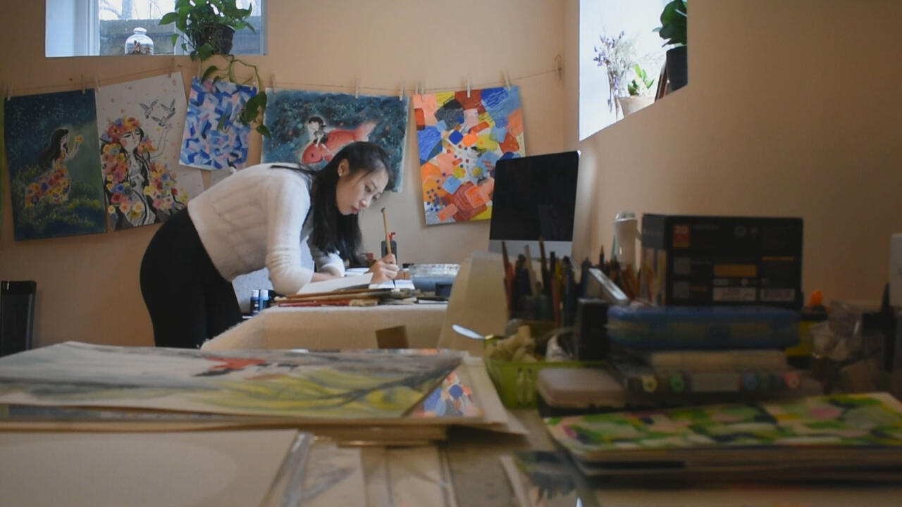 A horizontal photograph of Wenmen working in her studio  