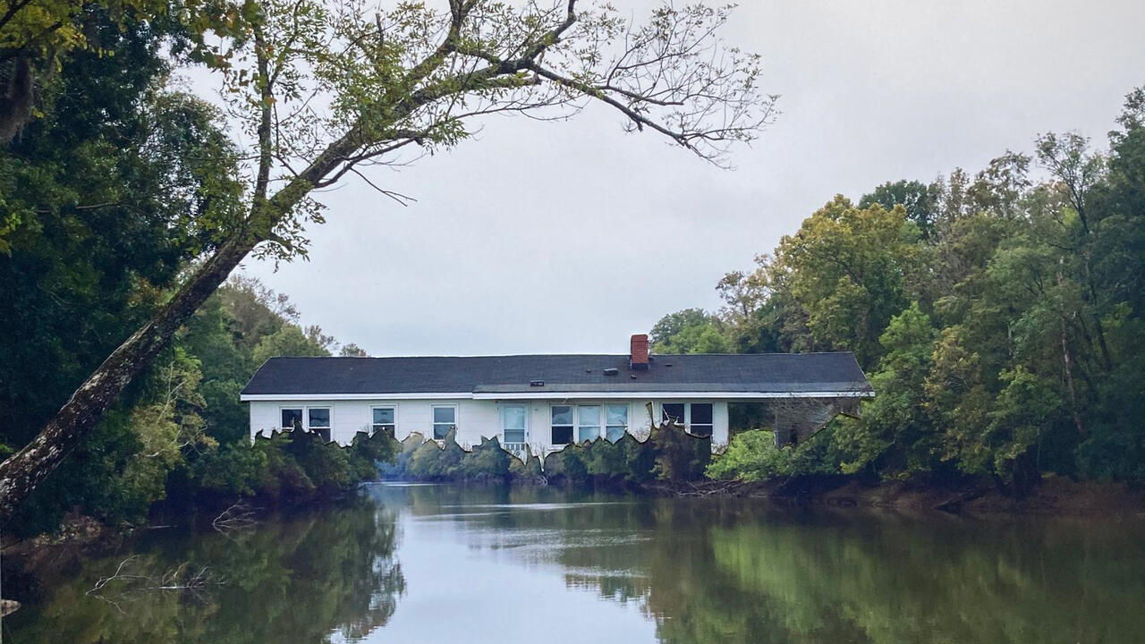 An edited photo of a house on a river surrounded by trees and greens