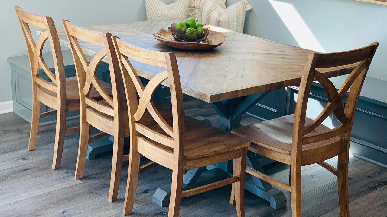 A table with chairs surrounding it and a small plant ontop of the table