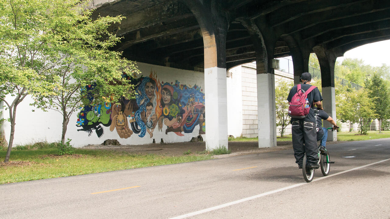 People biking by a mural