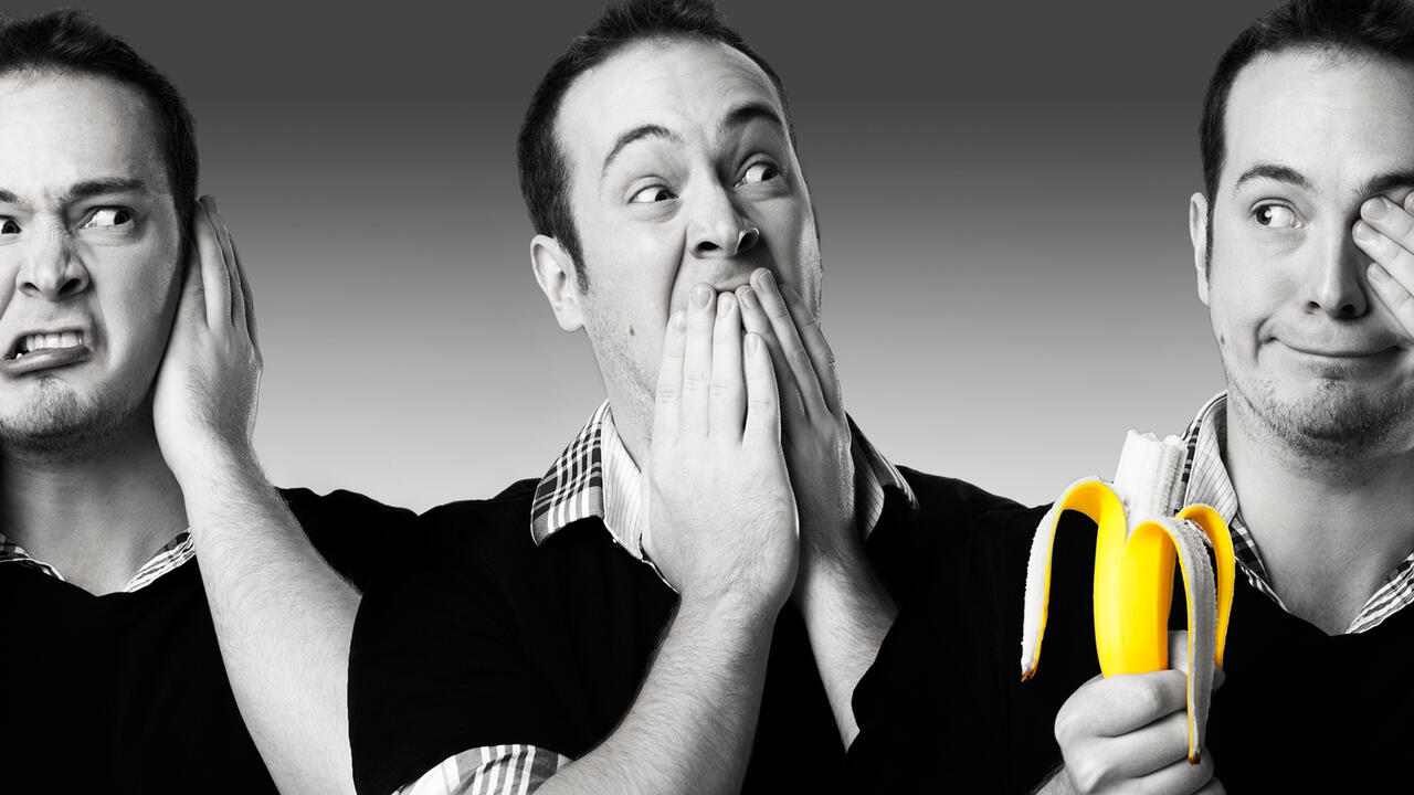 Three black and white photos of the same man acting out "hear no evil, speak no evil, see no evil" in the photo furthest to the right he is holding a banana which is in color