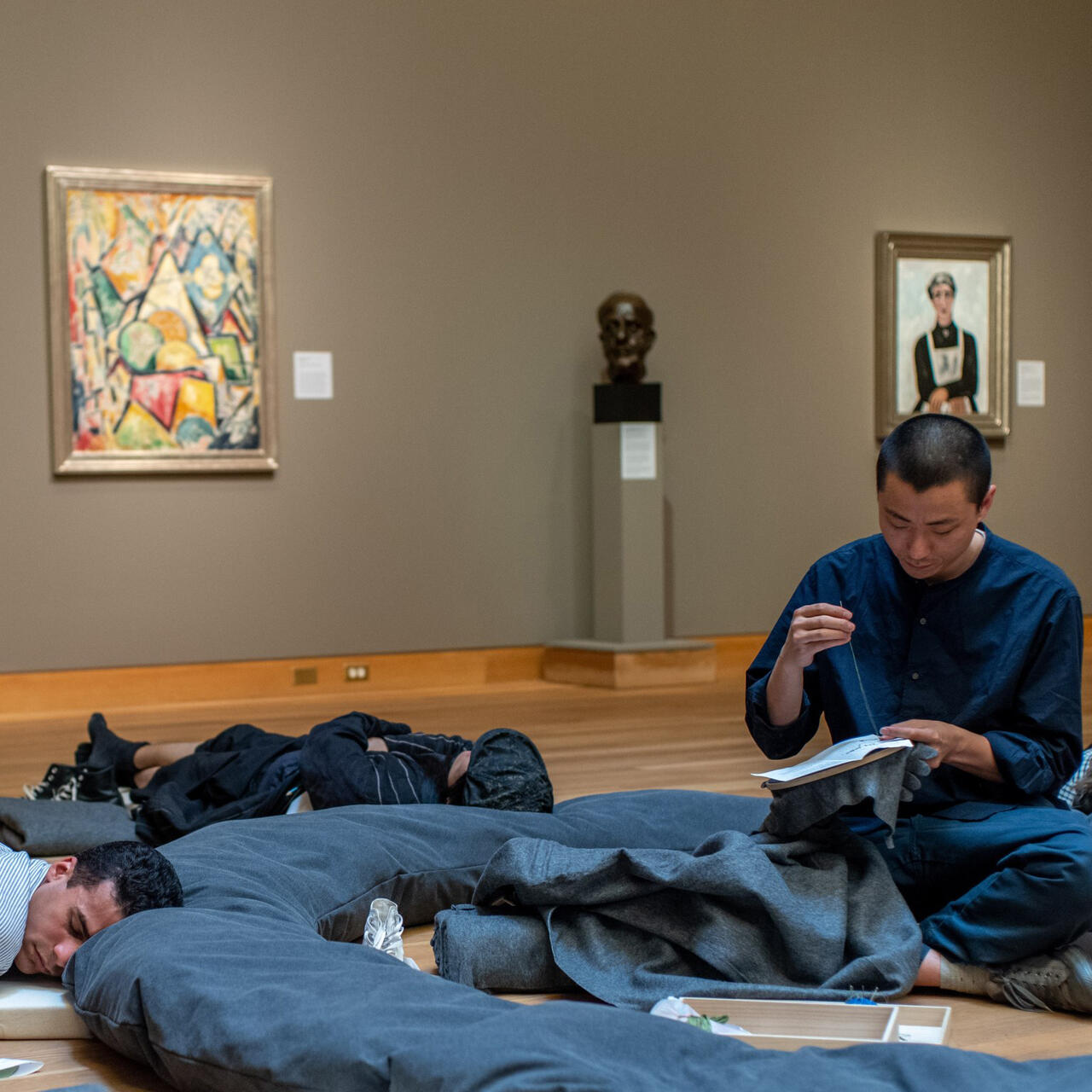 Peng Wu in a gallery with people laying on the ground