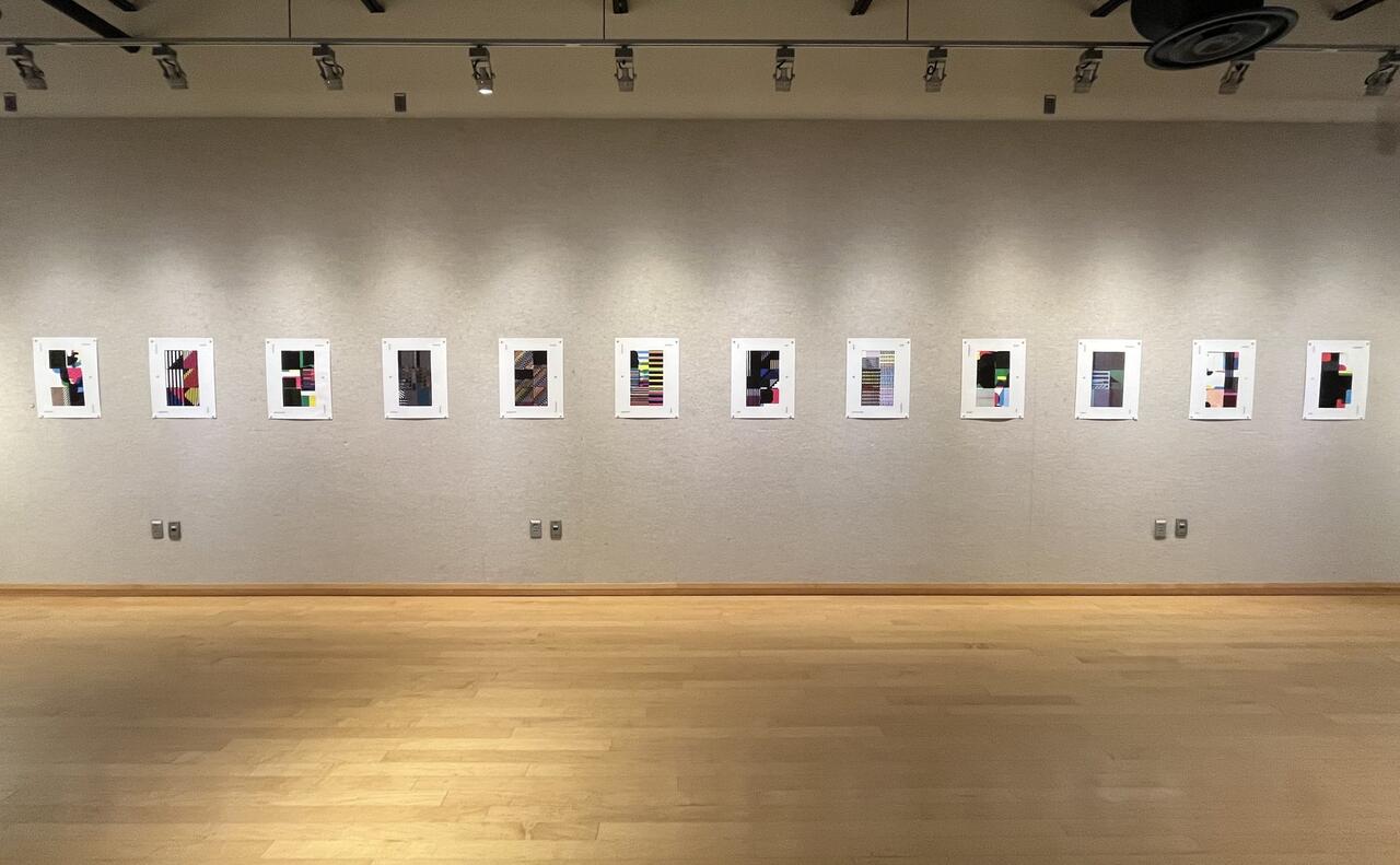 An image of an exhibition of graphic design images in a gallery.