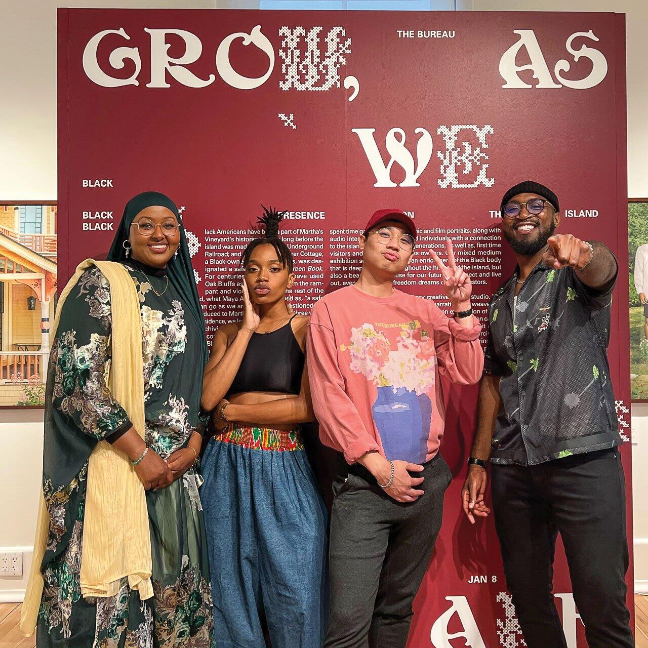 An image of four people standing in front of an exhibition's description display.