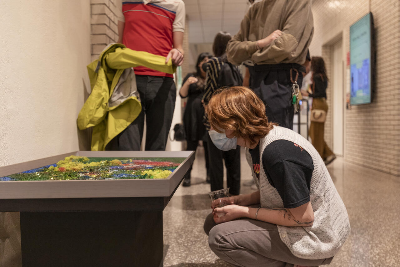 Student getting a close look at artwork by MFA student