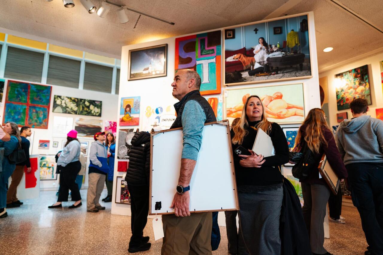 A photograph of buyers walking around MCAD's main gallery at their 27th annual art sale.