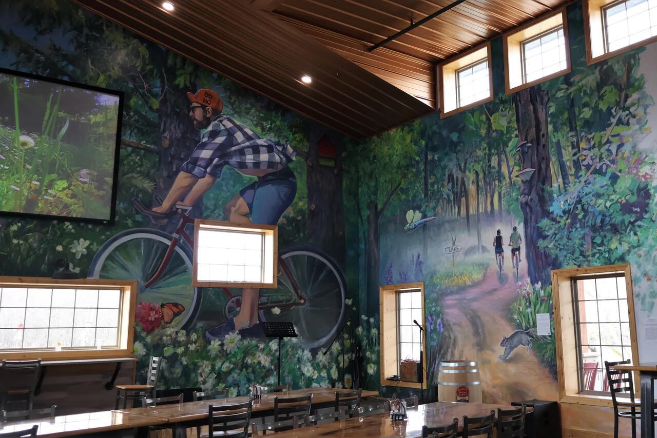 The mural at the Art in Motion art gallery. It features a landscape and a man biking.