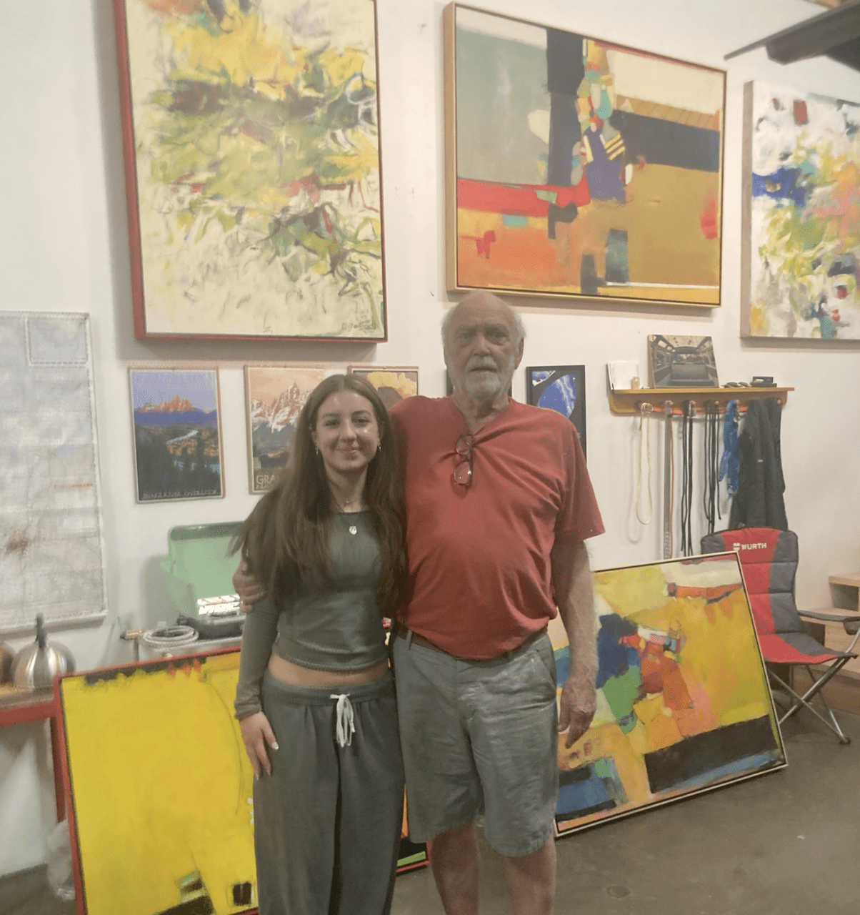 Hadley Dabish (left), and Don Grandbois (right) posing together in front of Grandbois paintings.