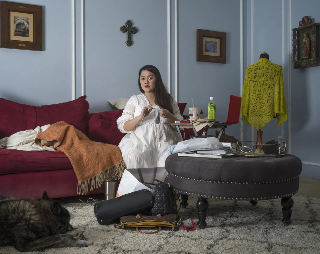 A photgraph of a woman sitting on a couch in a living room.